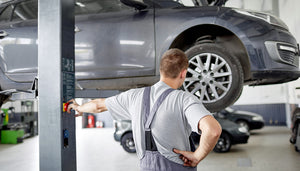 mechanic puts car up on lift