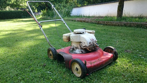 Old Lawn Mower on green lawn