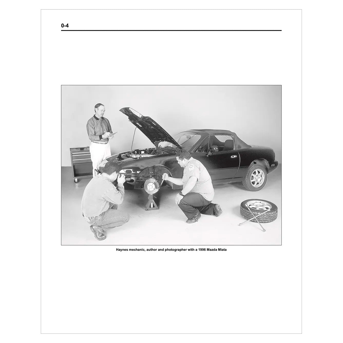 Black and white photo of three men working on a car with an open hood.